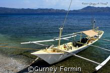 Dive boat with a sleeping boatman on a surface interval. by Gurney Fermin 